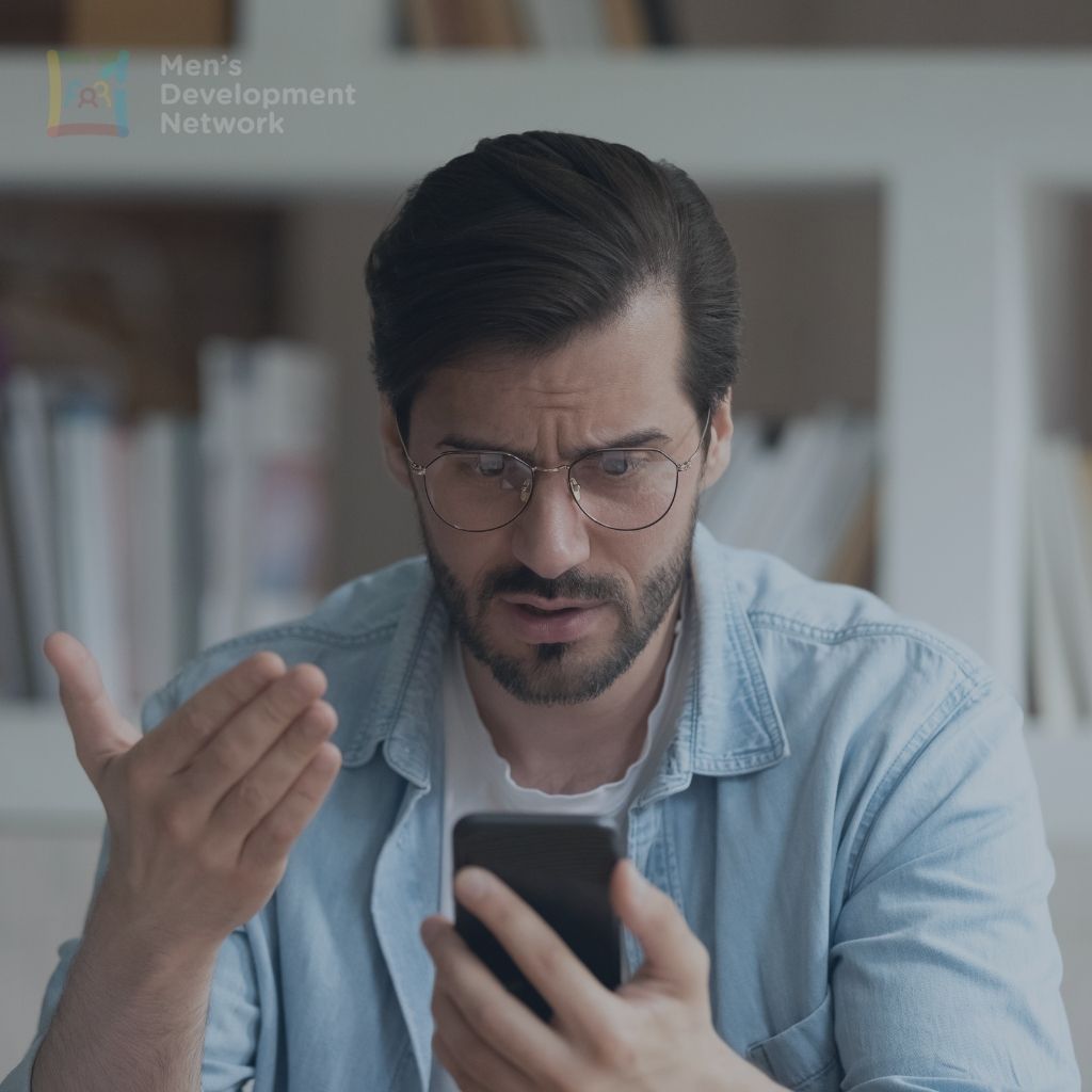 A man looking frustrated at his phone, illustrating how online content can provoke emotional reactions known as rage bait.